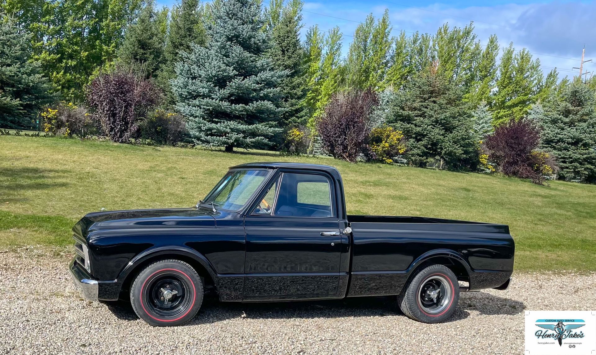 A black pickup truck is parked in a gravel lot.
