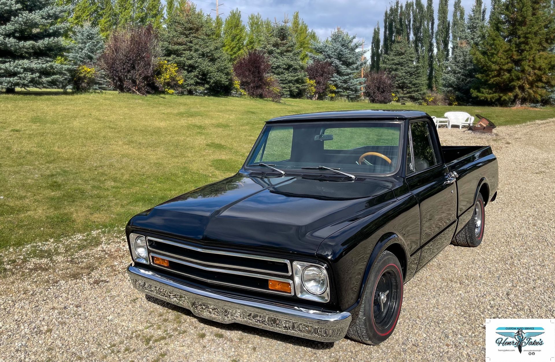 A black pickup truck is parked on a gravel road.