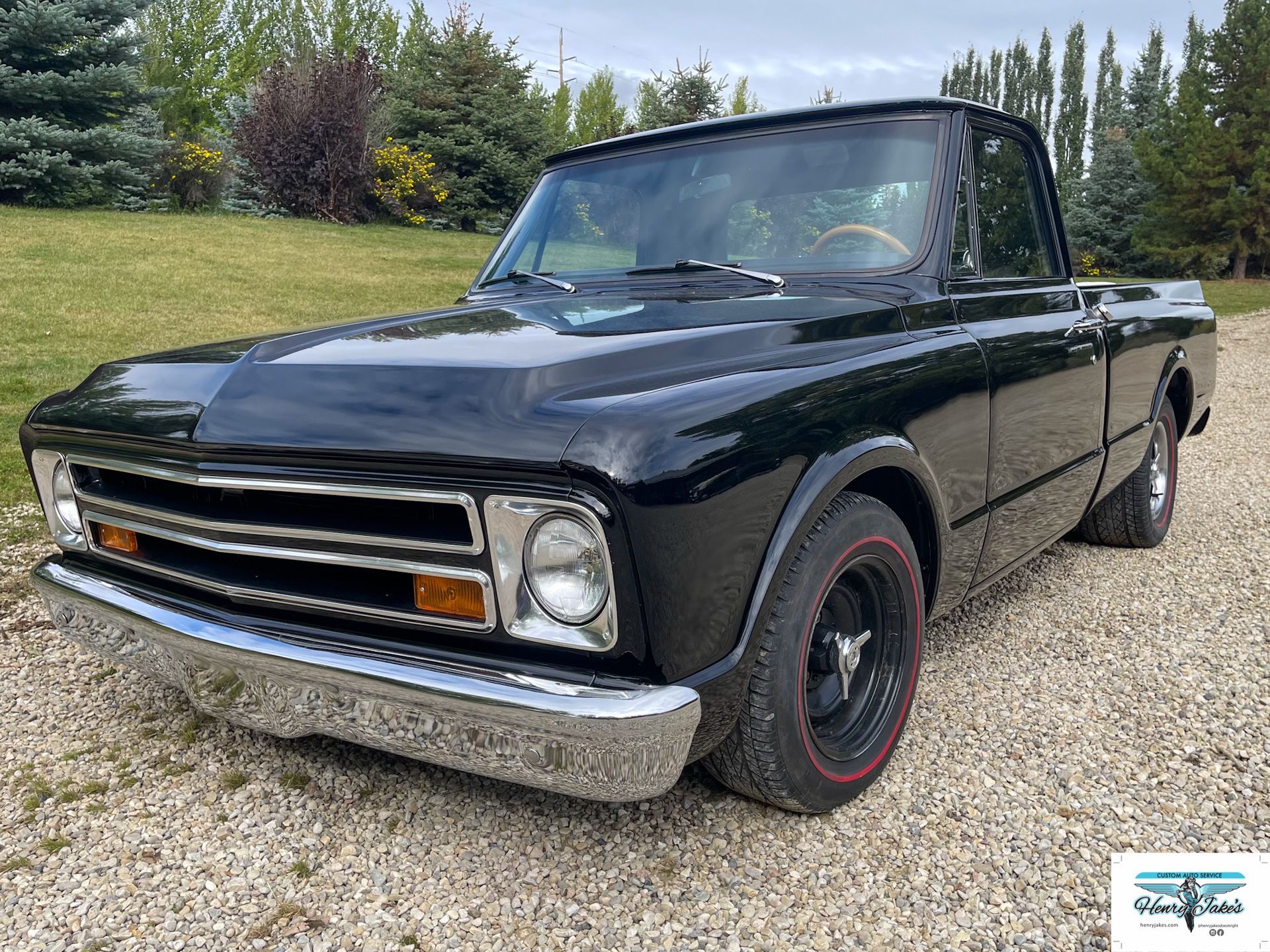 A black pickup truck is parked on a gravel road.