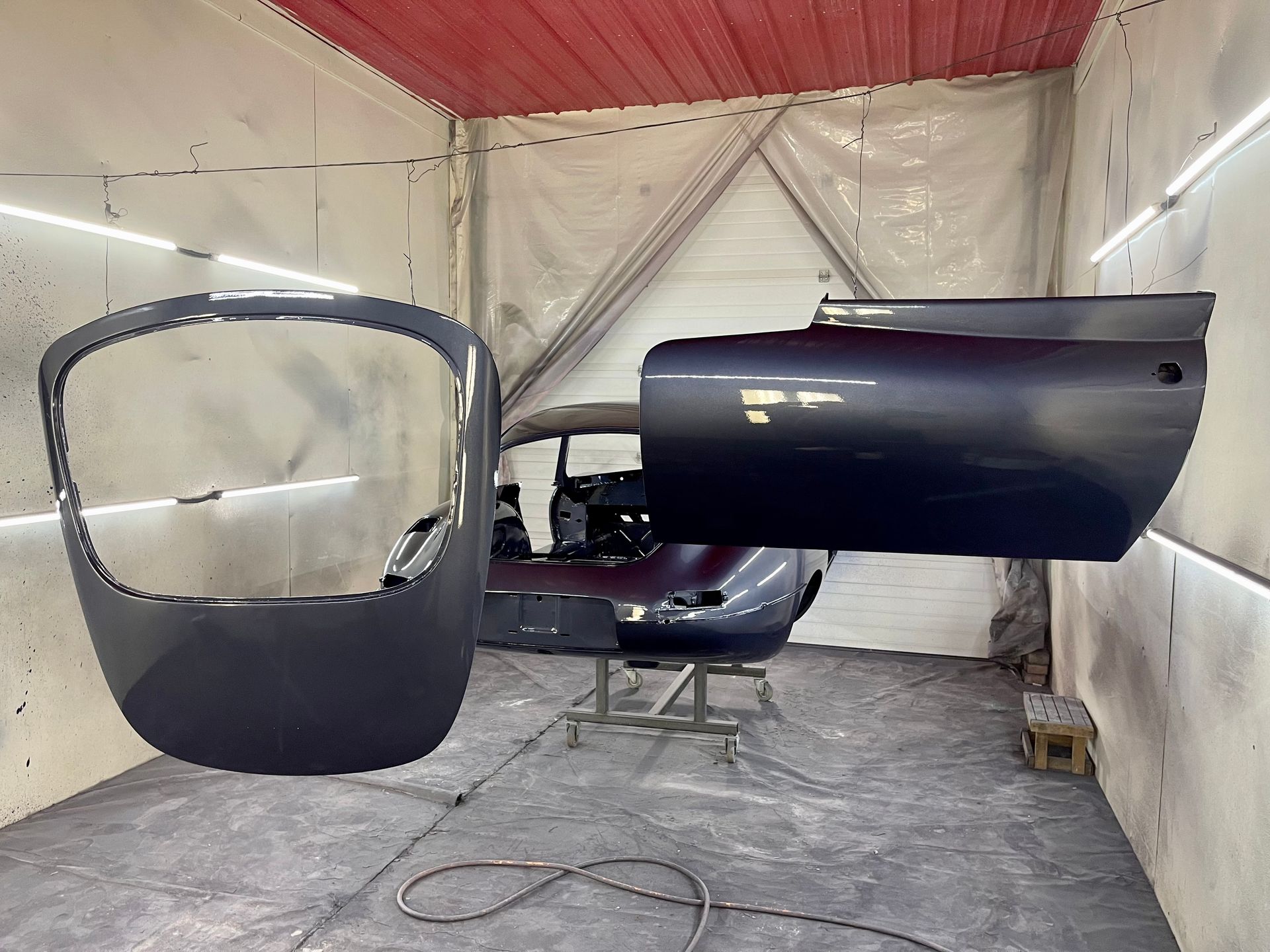 A car is being painted in a paint booth.