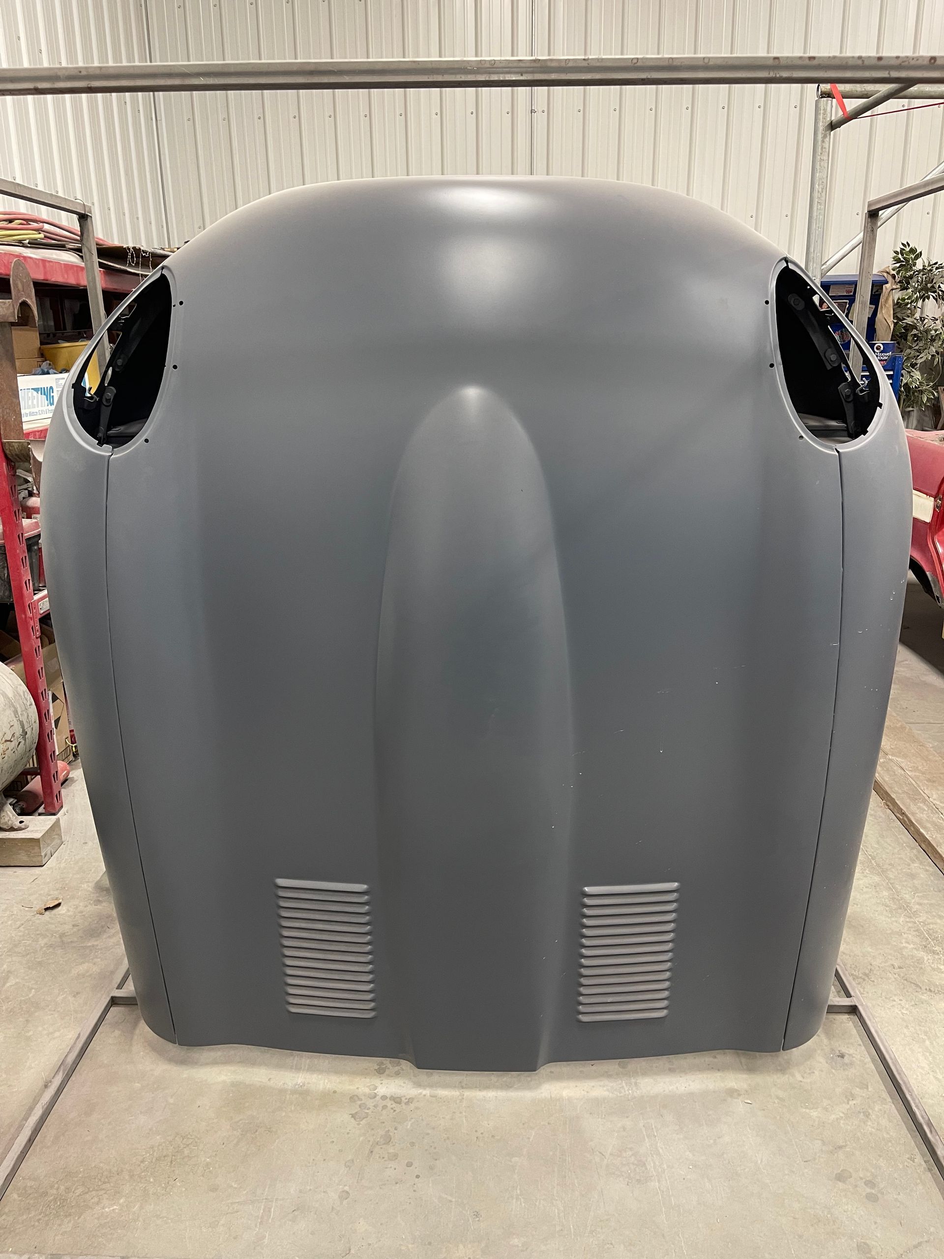 A large gray object is sitting on the ground in a garage.