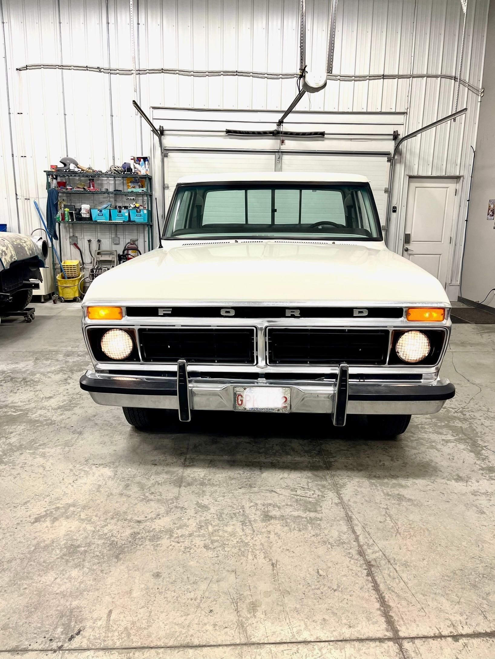 A white ford truck is parked in a garage.