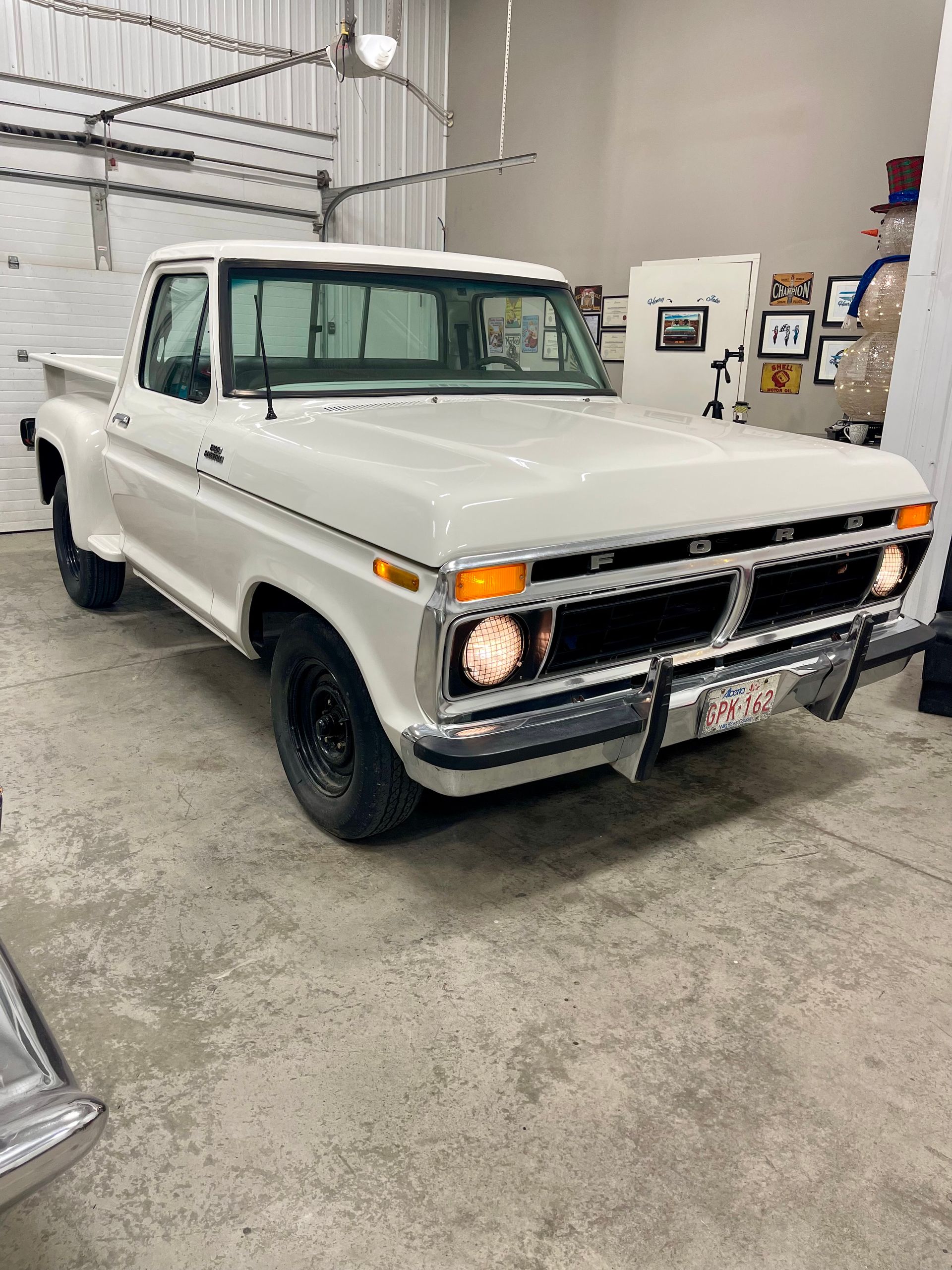 A white pickup truck is parked in a garage.