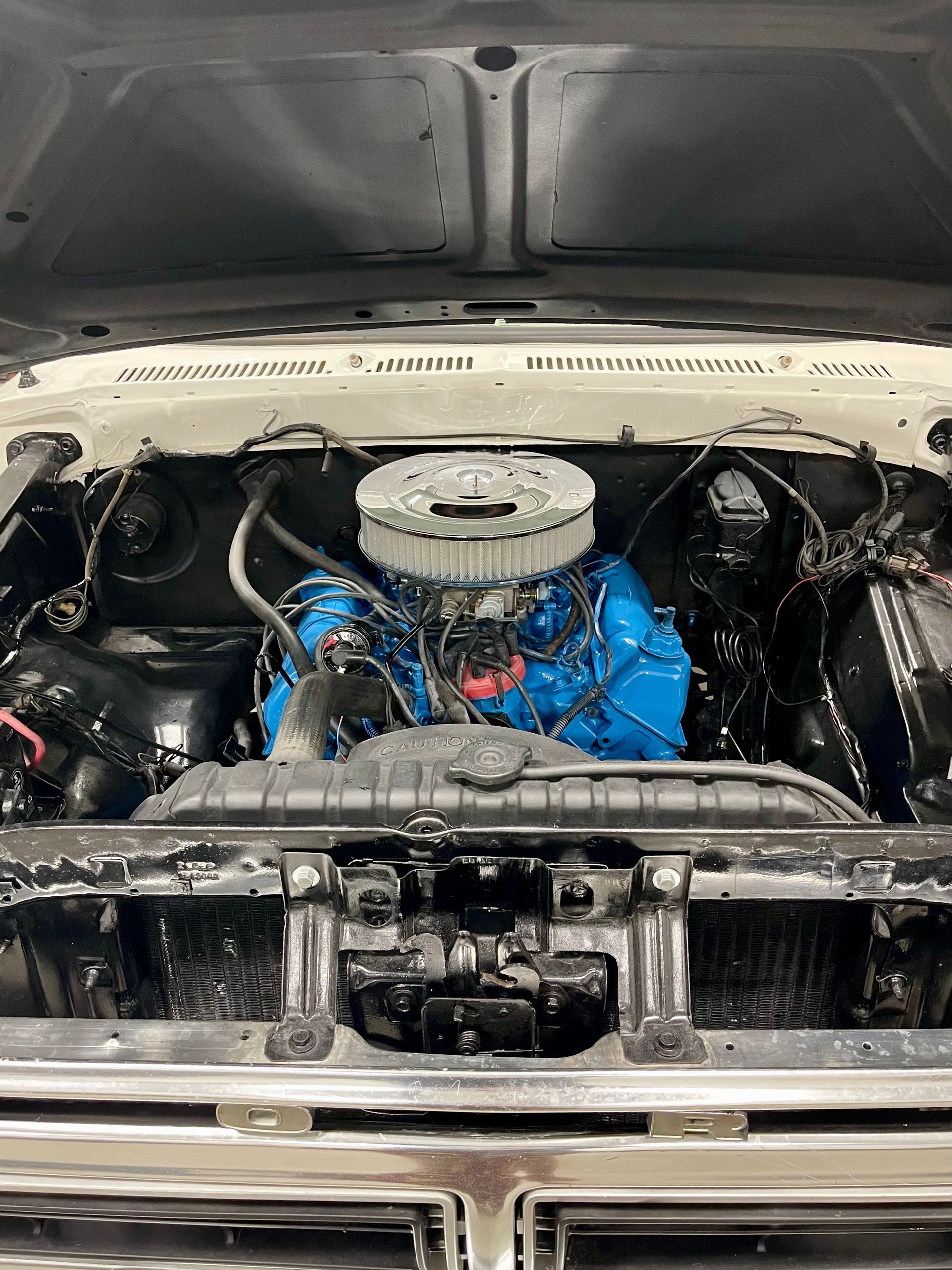 A close up of a car engine with the hood open.