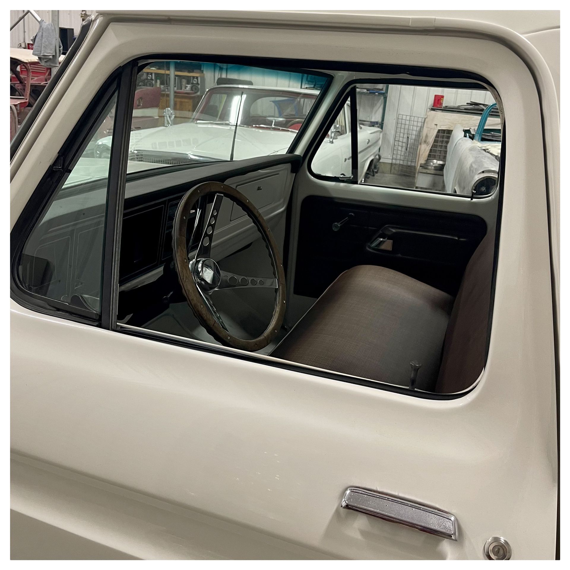 A white truck with a brown seat and steering wheel