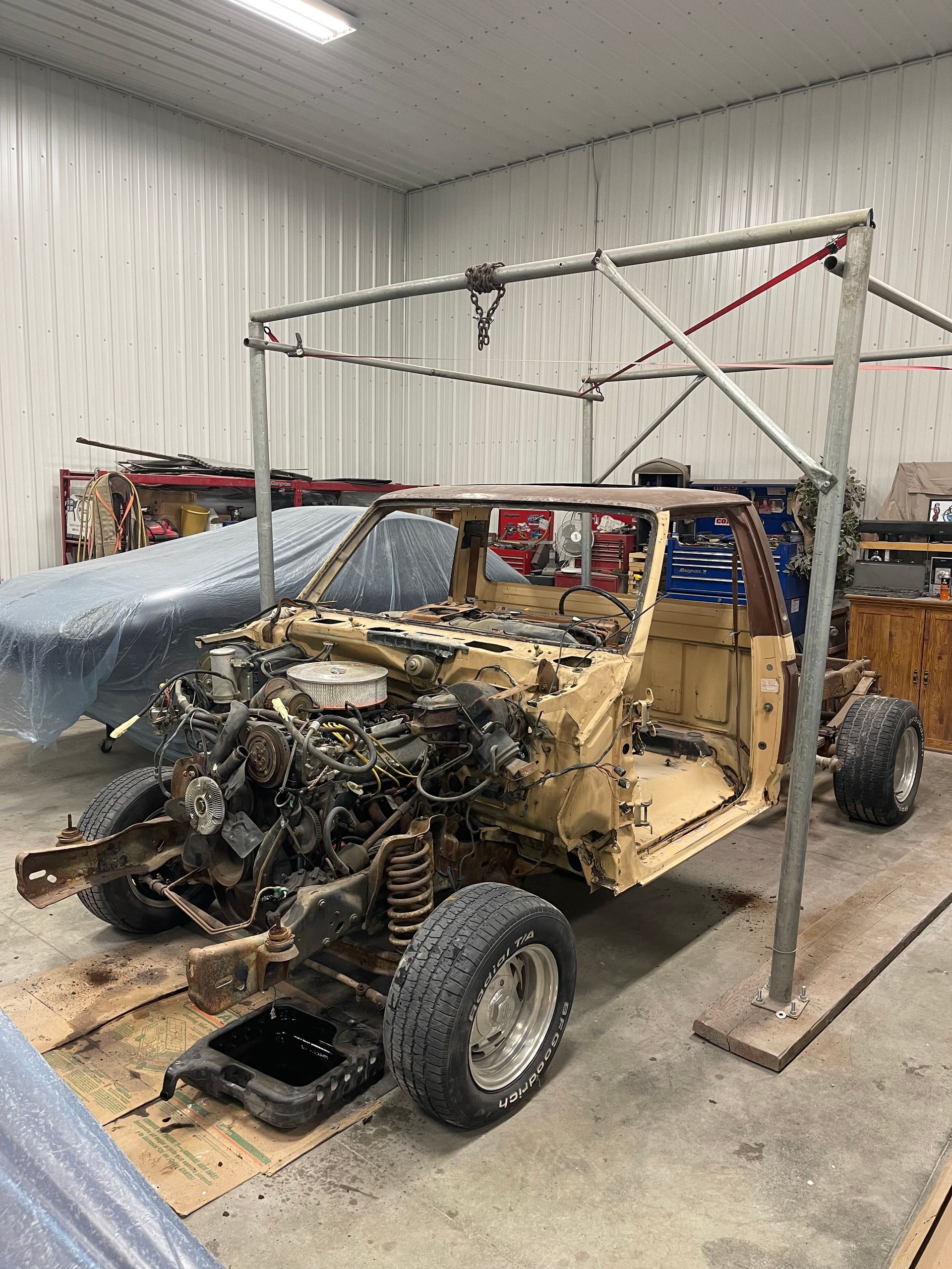 A jeep is being dismantled in a garage.