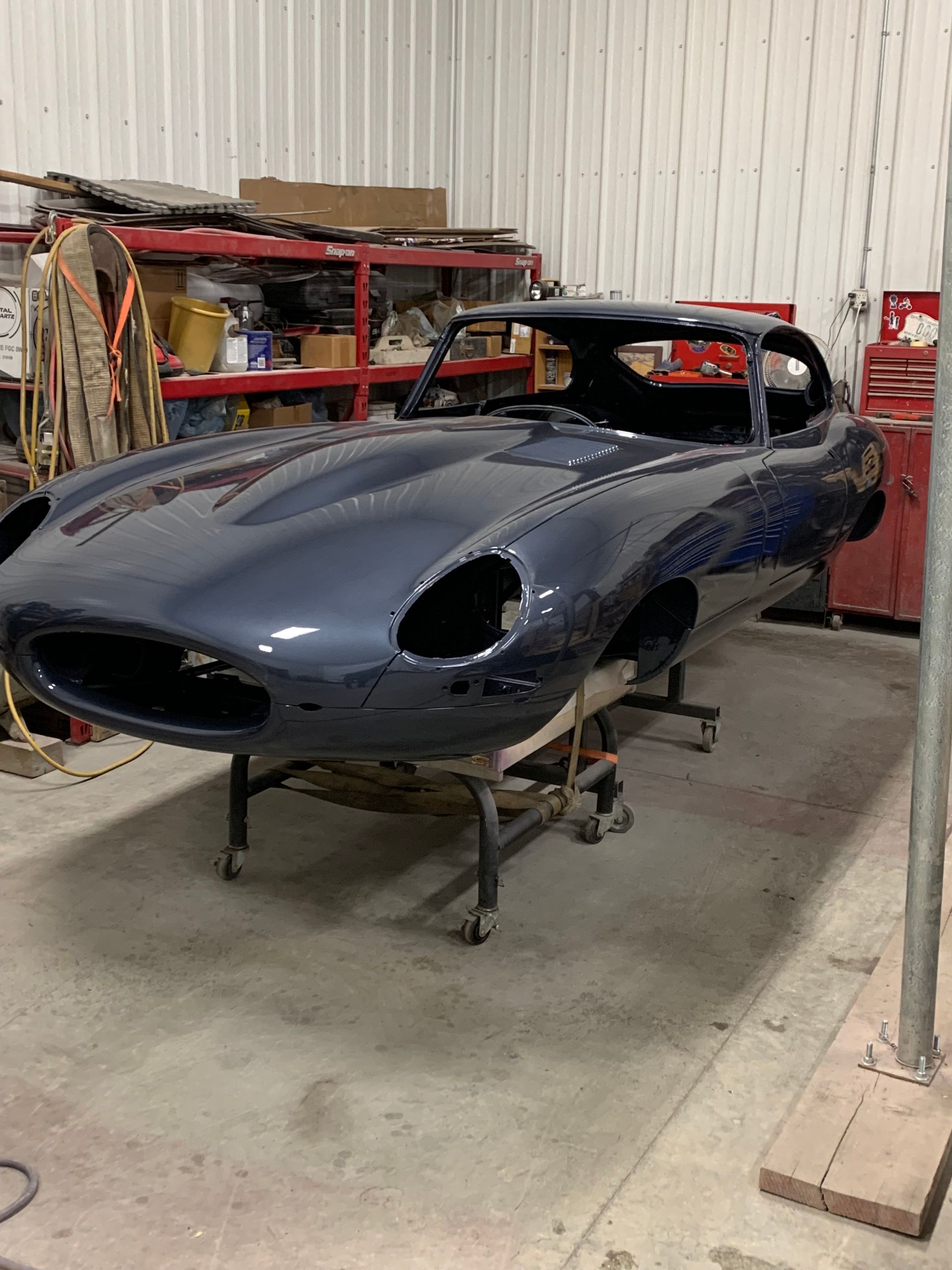 A blue car is sitting on a table in a garage.