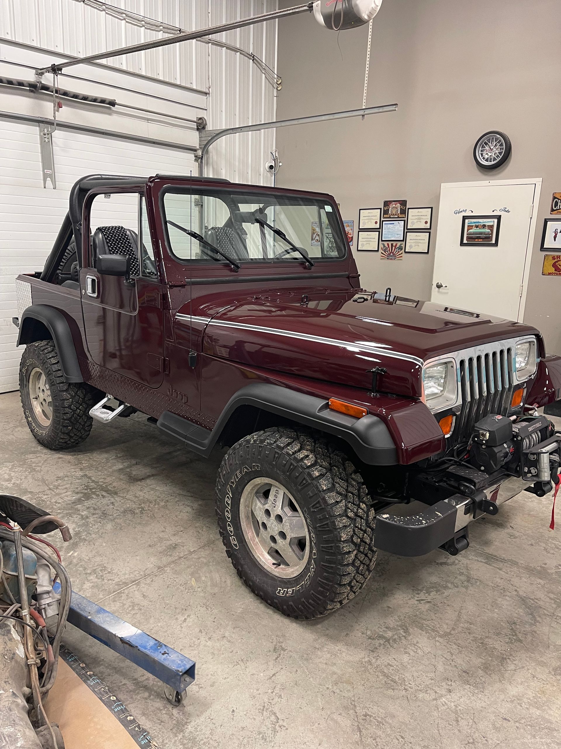 A red jeep is parked in a garage.