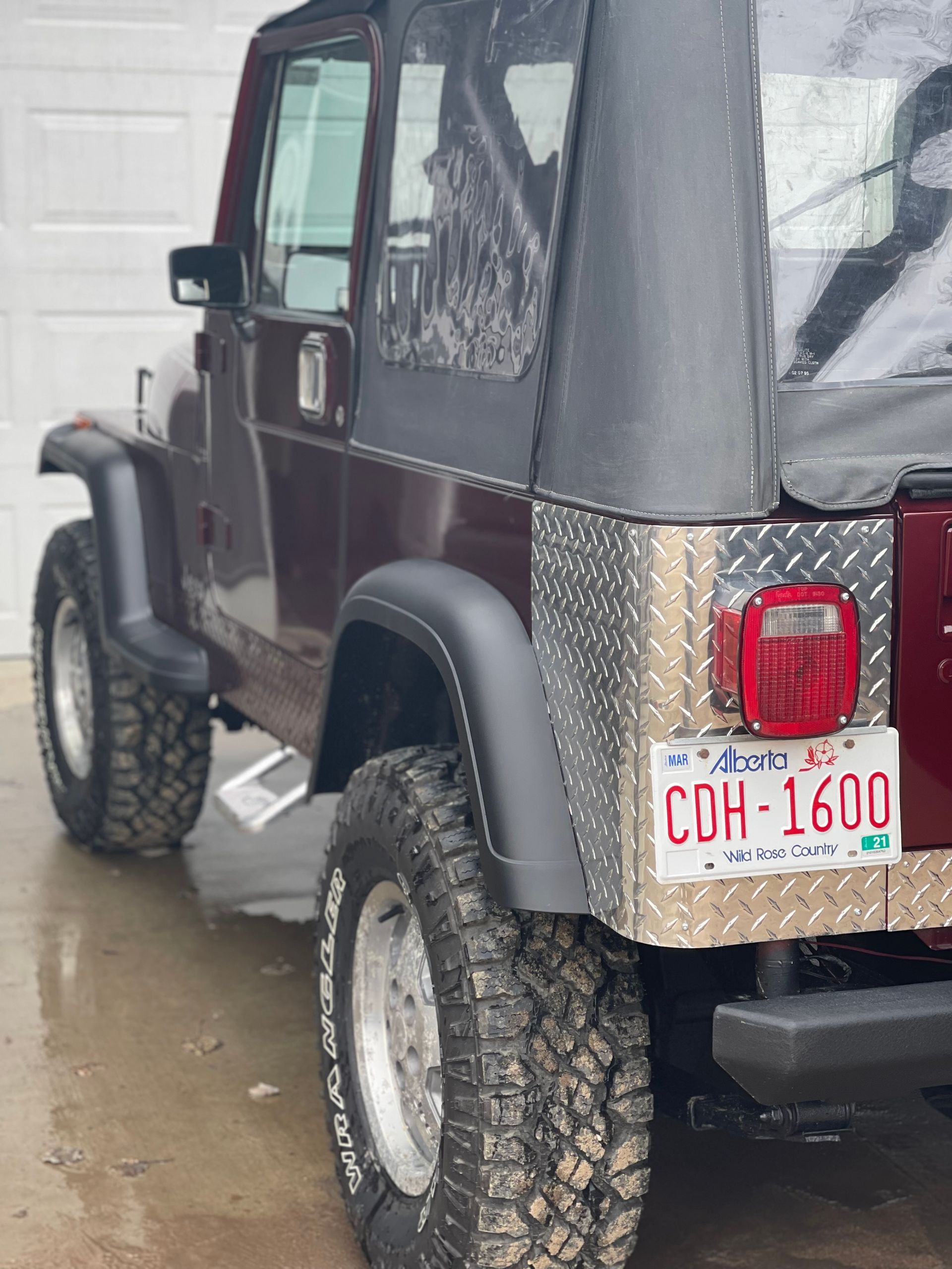 A jeep with a license plate that says coh 1600 is parked in a garage.