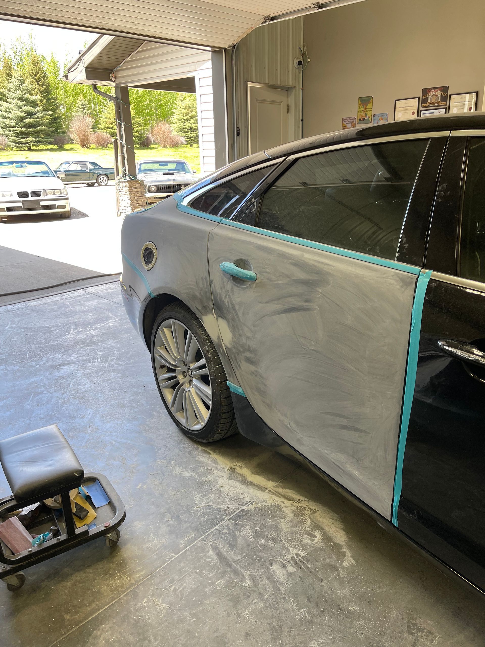 A car is being painted in a garage.