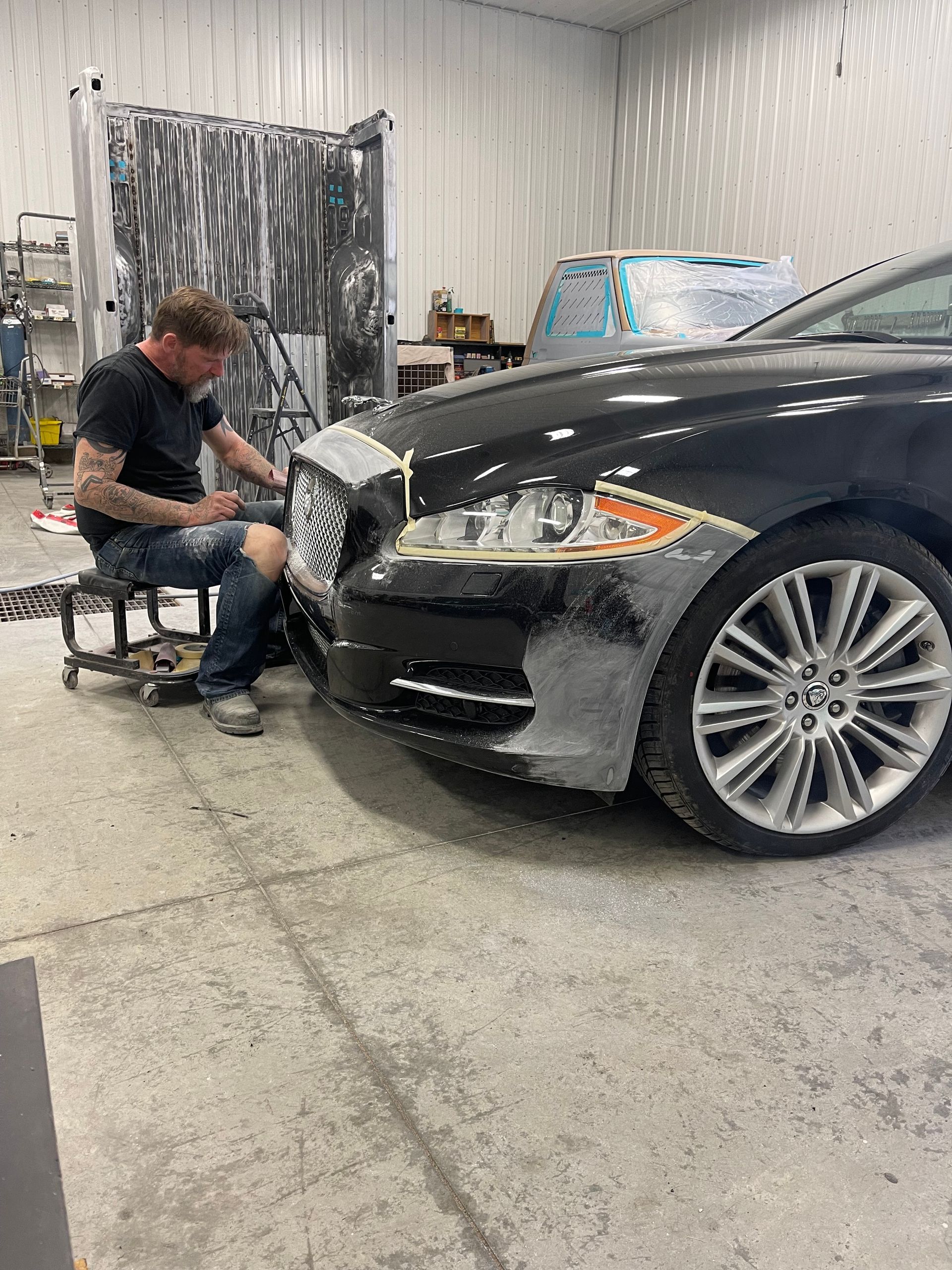 A man is working on a car in a garage.