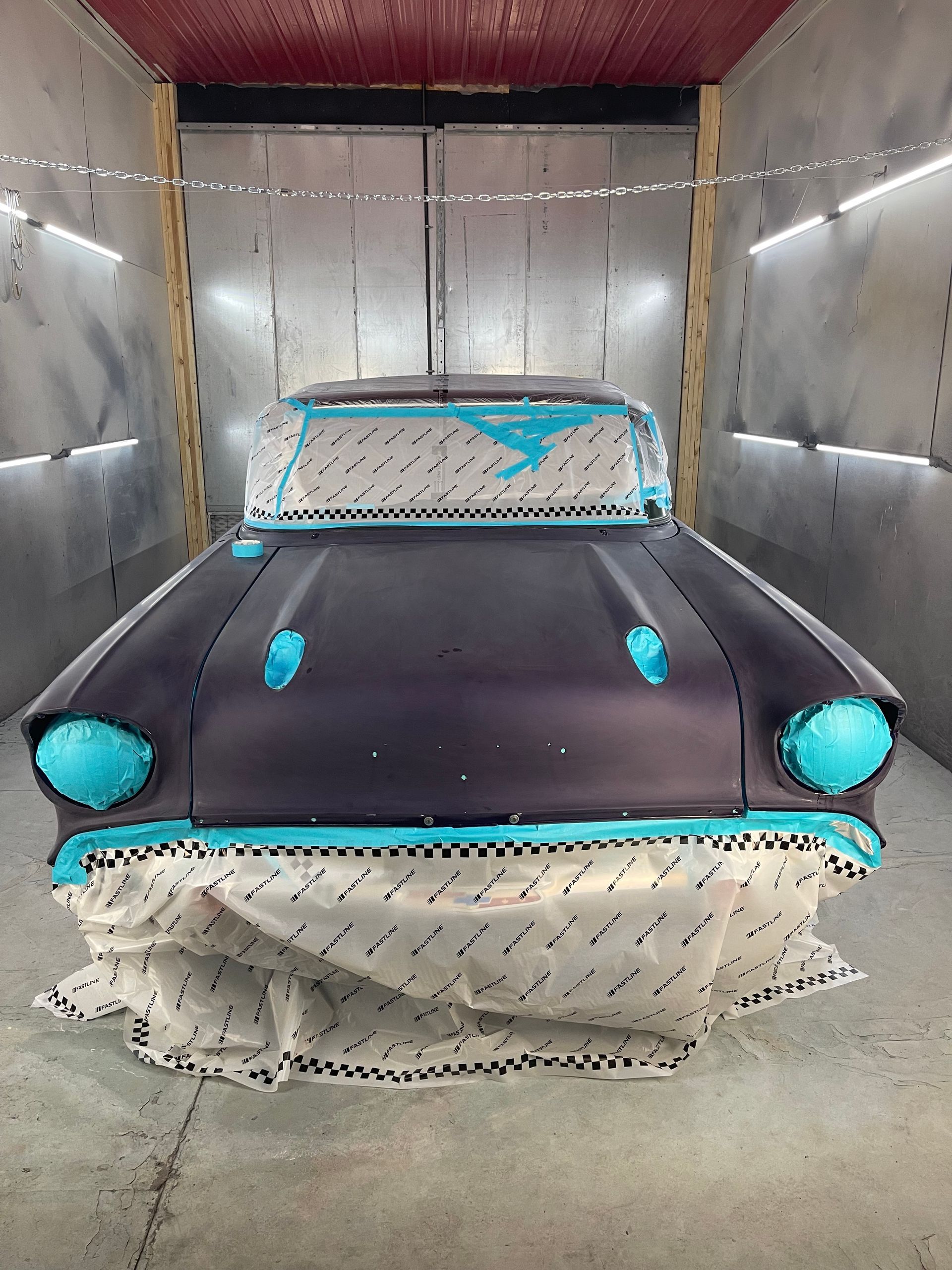 A car is being painted in a paint booth.