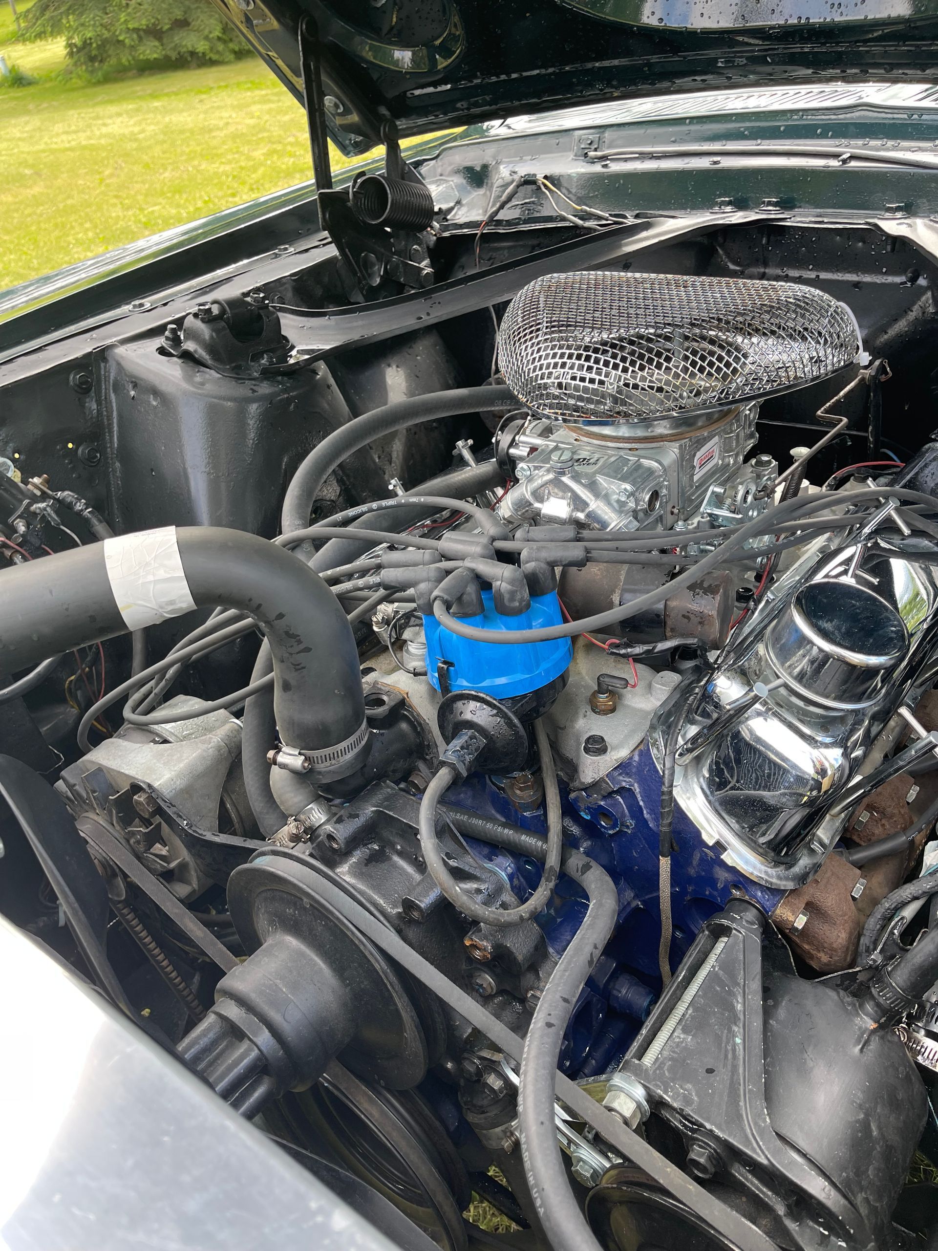 A close up of a car engine with the hood up.