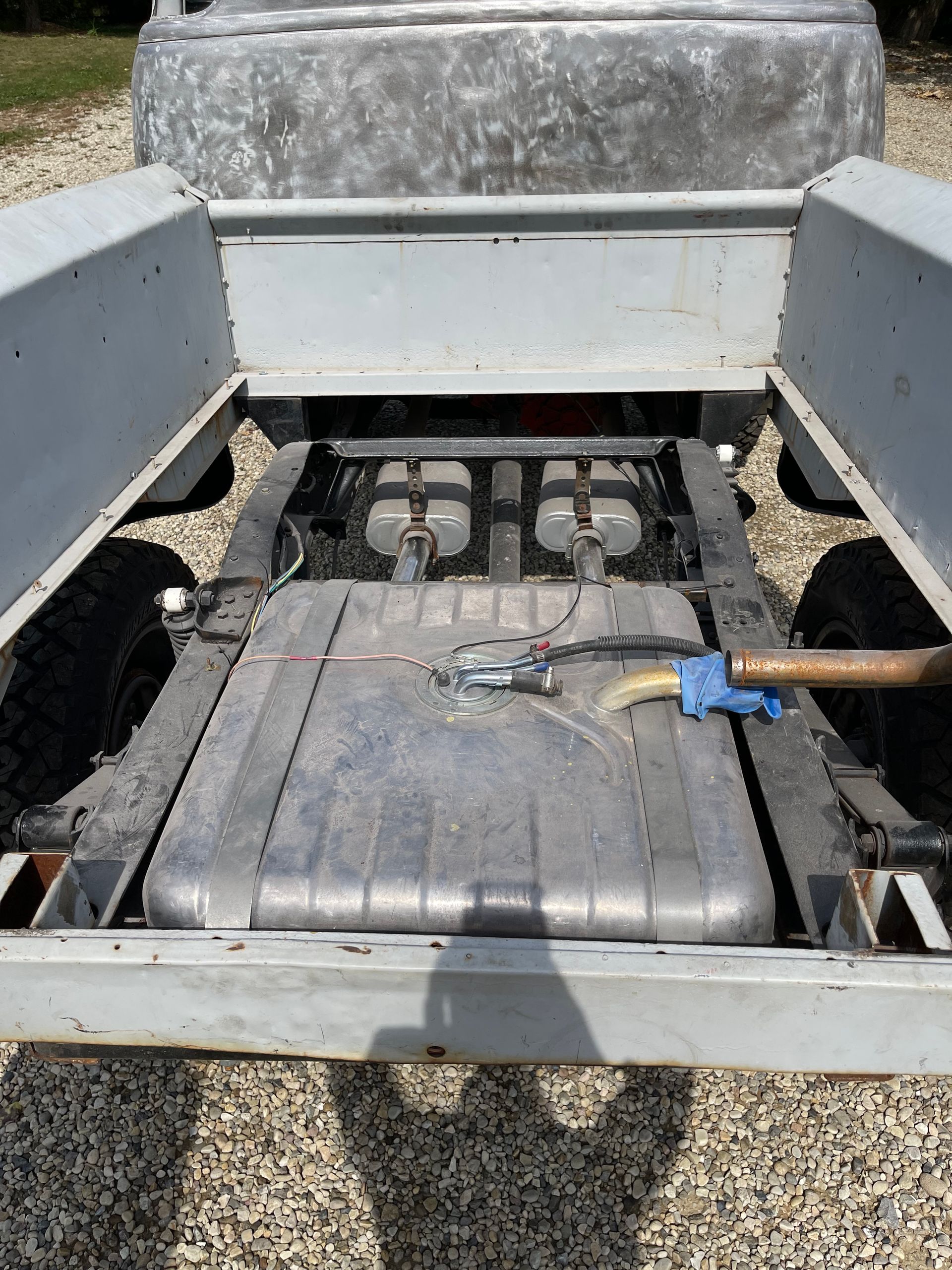 The back of a truck with a fuel tank and a shovel in it.