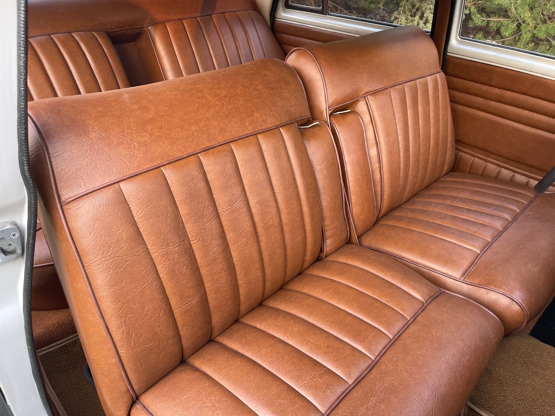 The back seat of a car with brown leather seats