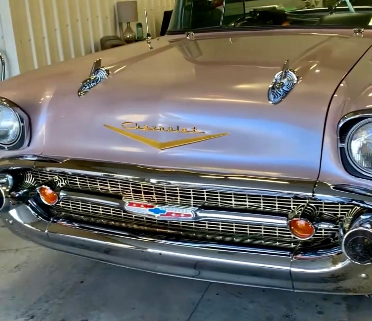 A pink chevrolet is parked in a garage