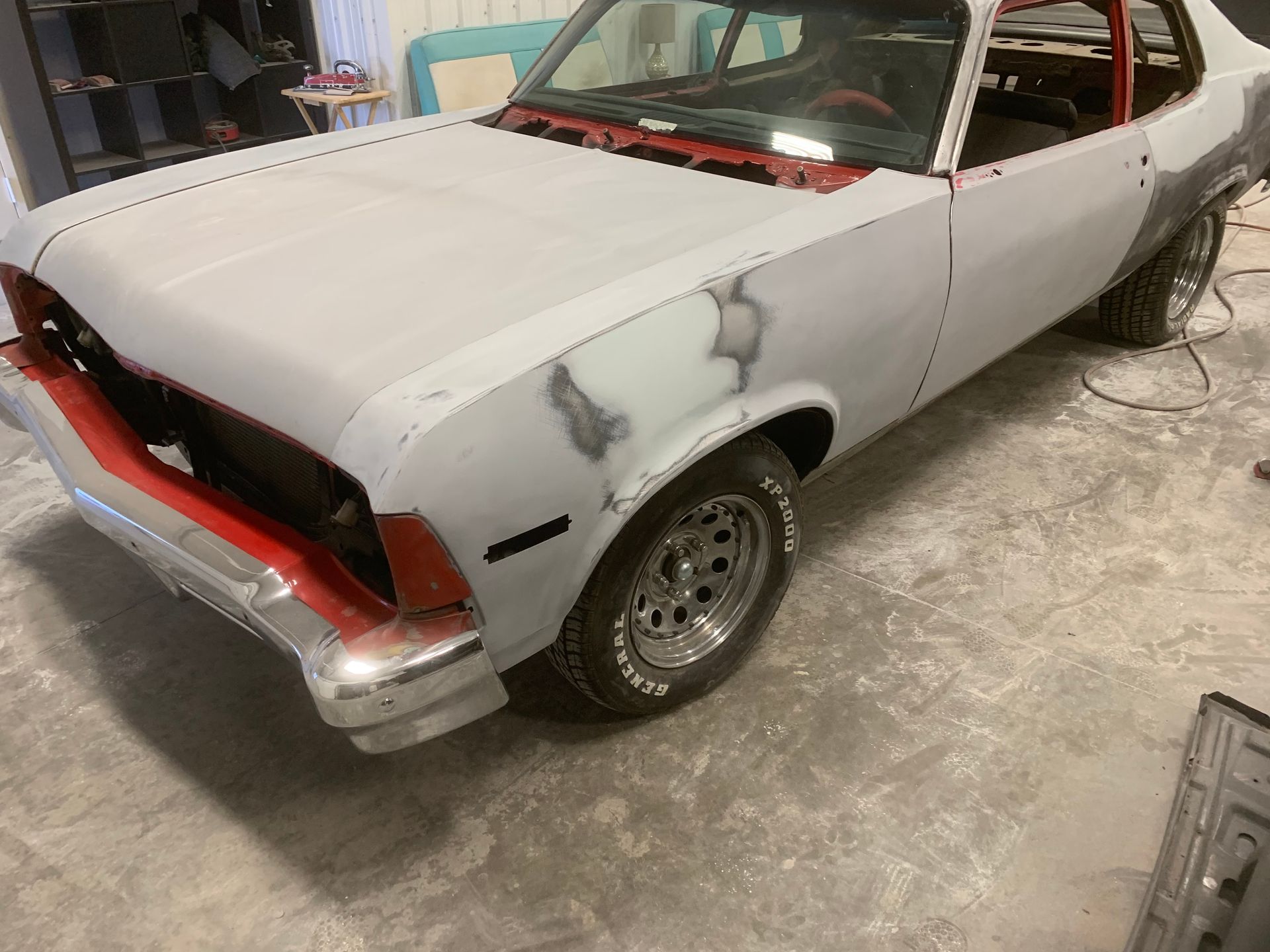 A white car with red trim is parked in a garage.
