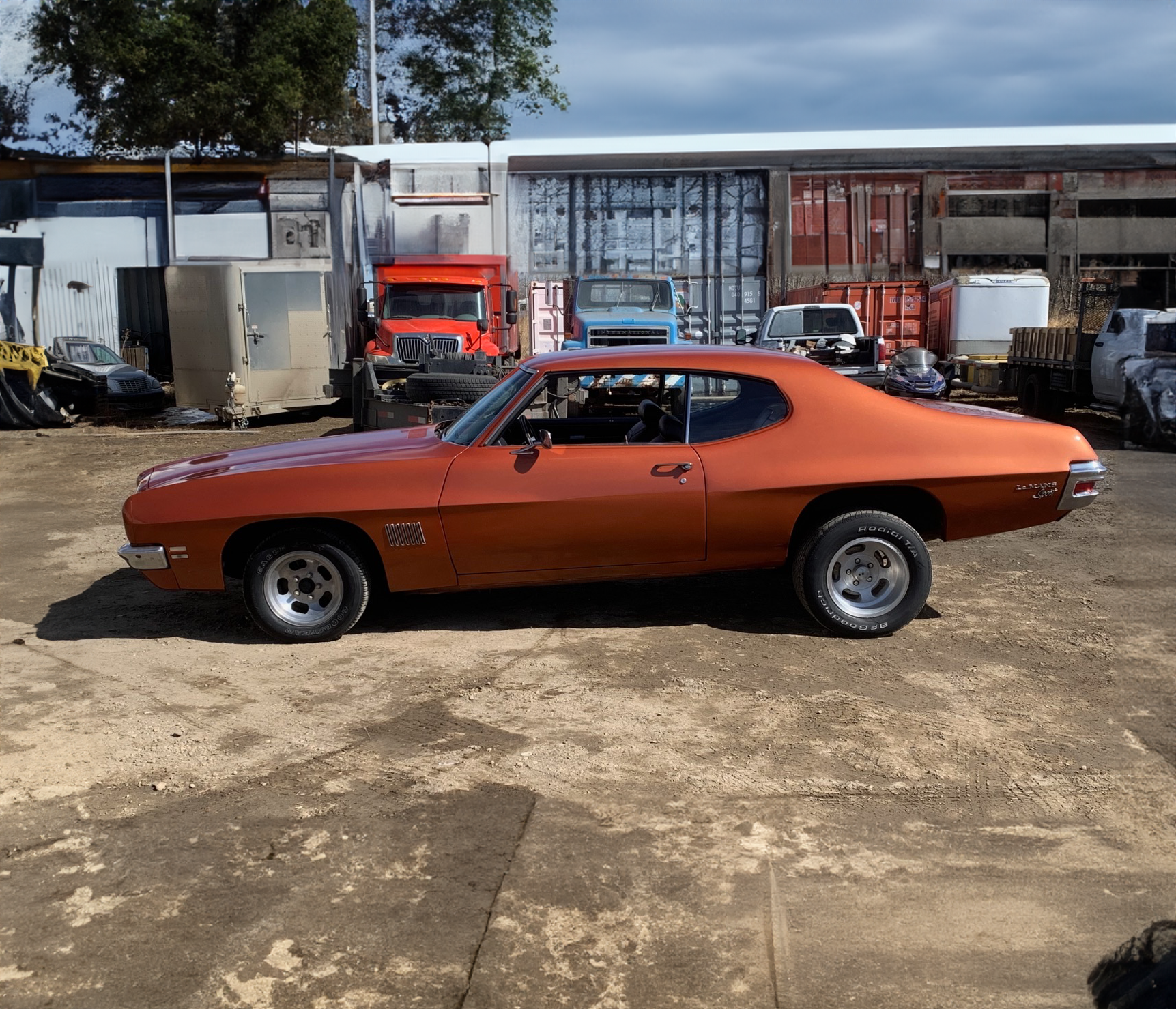 An orange car is parked in a parking lot