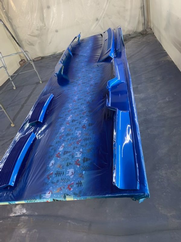 A blue table is sitting in a room covered in plastic.