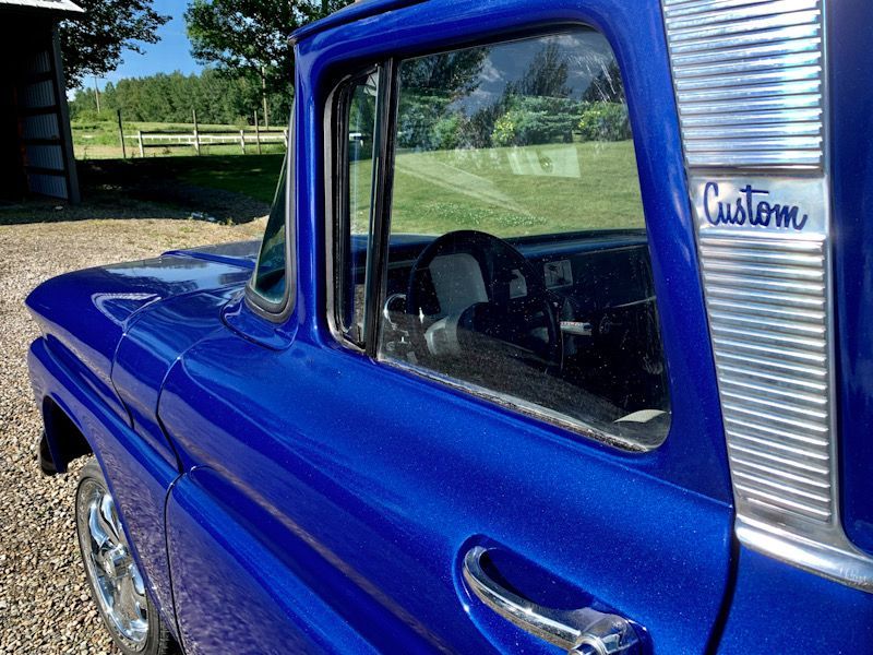 A blue truck with the word custom on the side