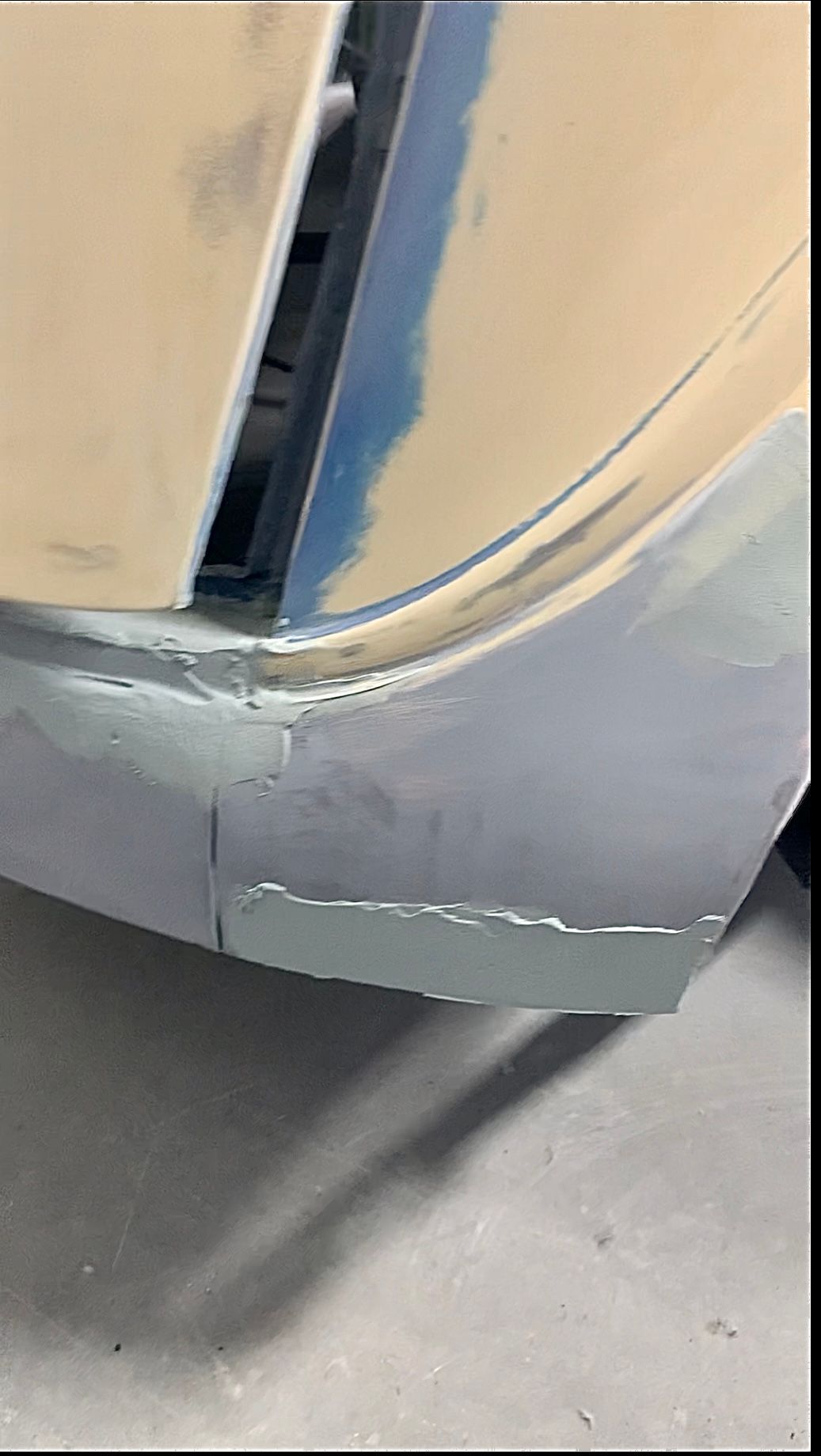 A close up of a car bumper that is being painted.