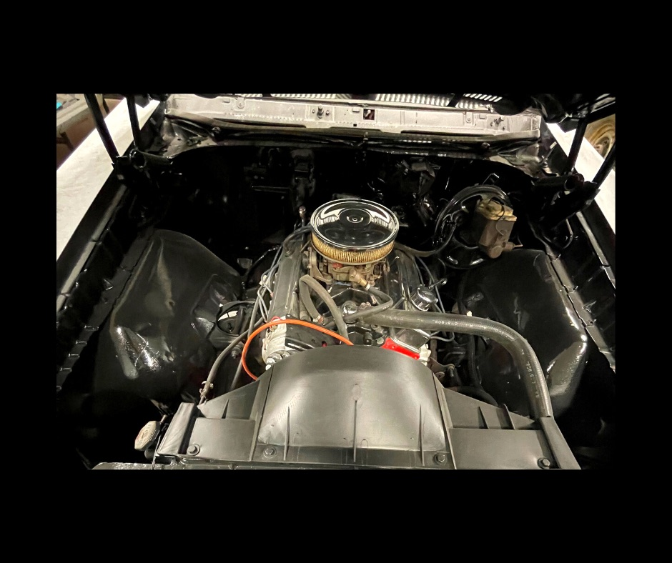 A close up of a car engine with a hood open.