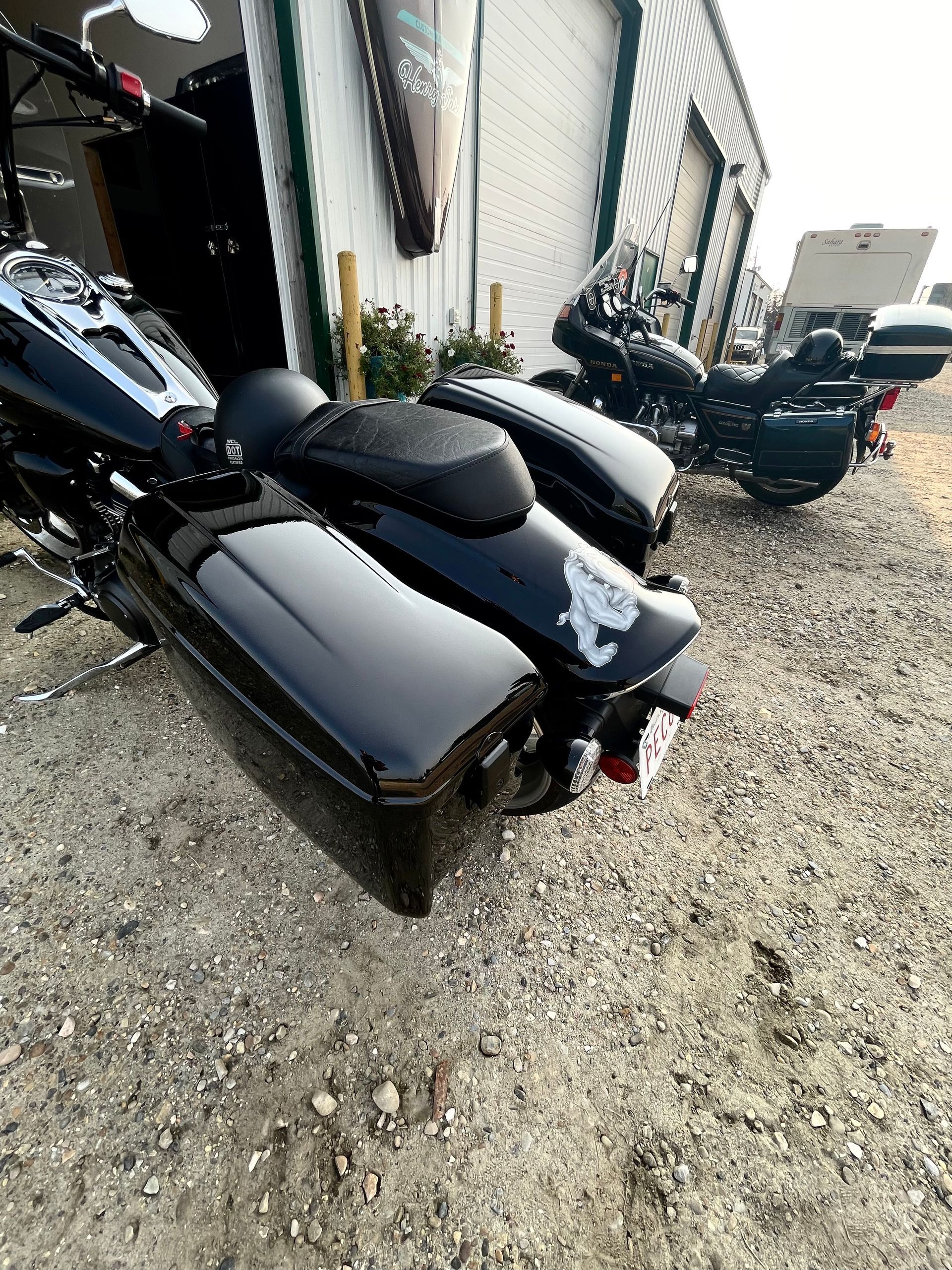 A black motorcycle is parked in front of a building.