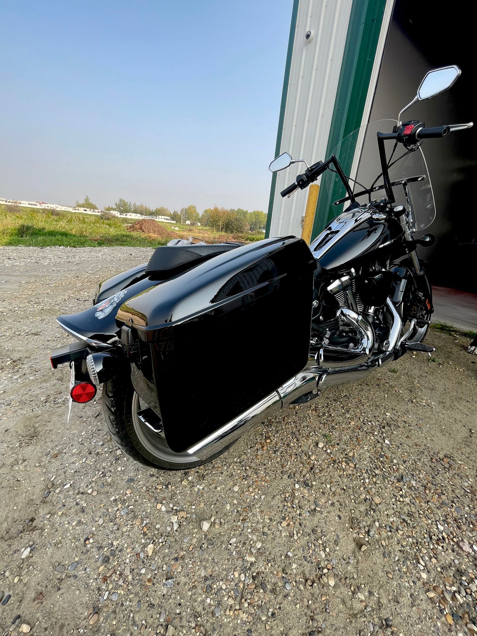 A black motorcycle is parked in front of a garage.