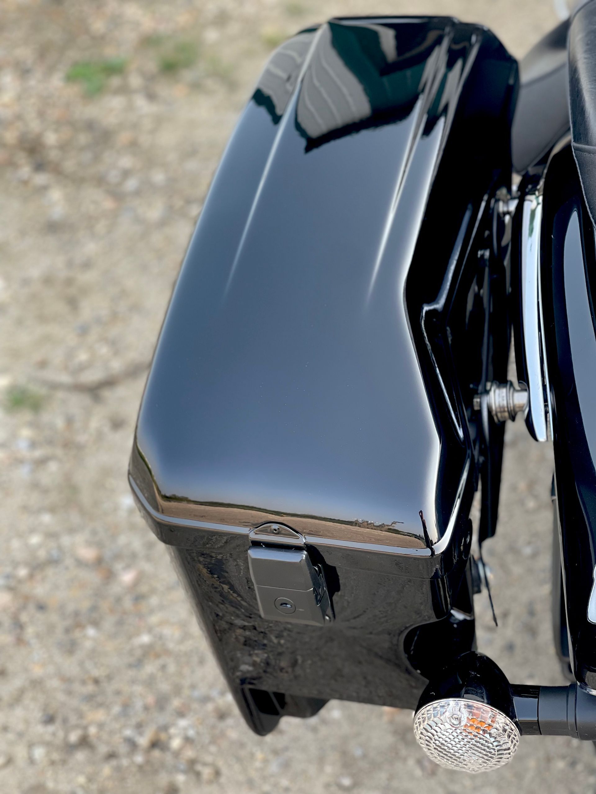 A black motorcycle is parked on a gravel road