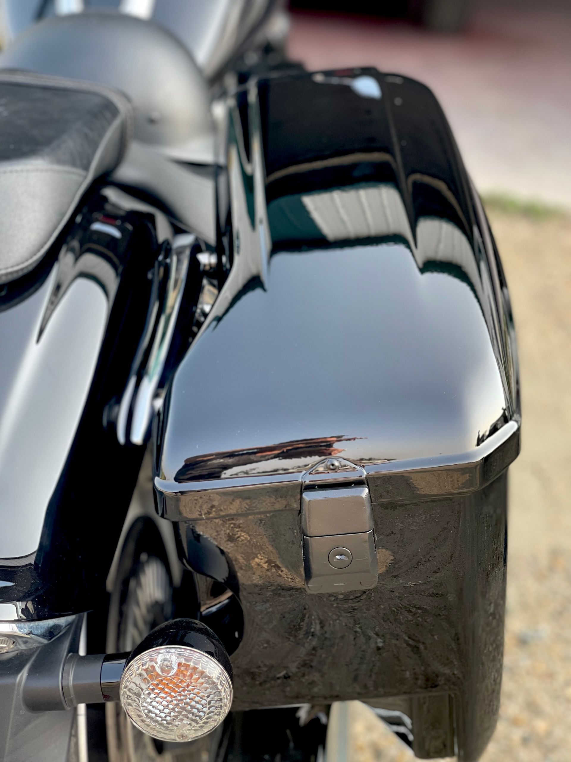 A close up of a black motorcycle with a trunk