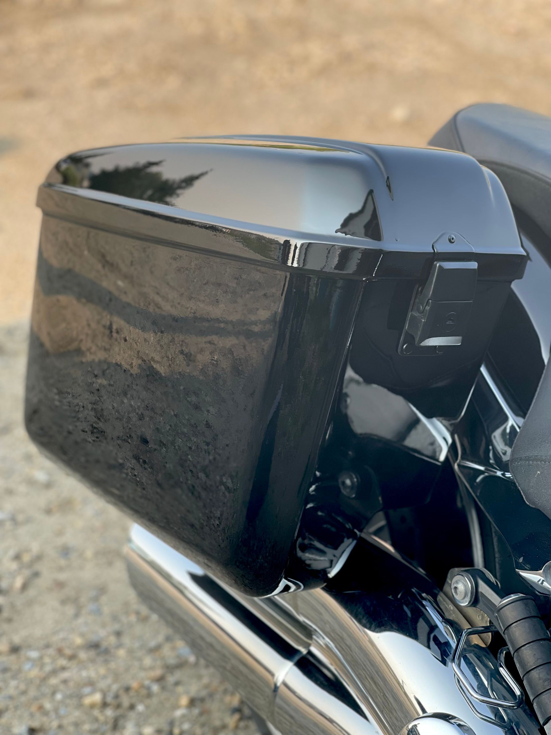 A black motorcycle is parked on a gravel road