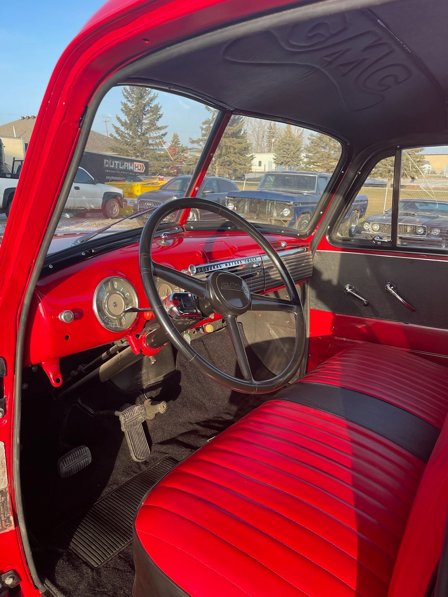The interior of a red truck with red seats and a steering wheel.