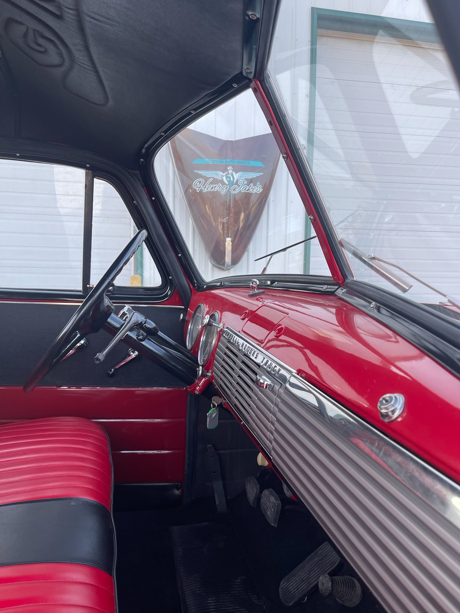The inside of a red car with black seats and a steering wheel.