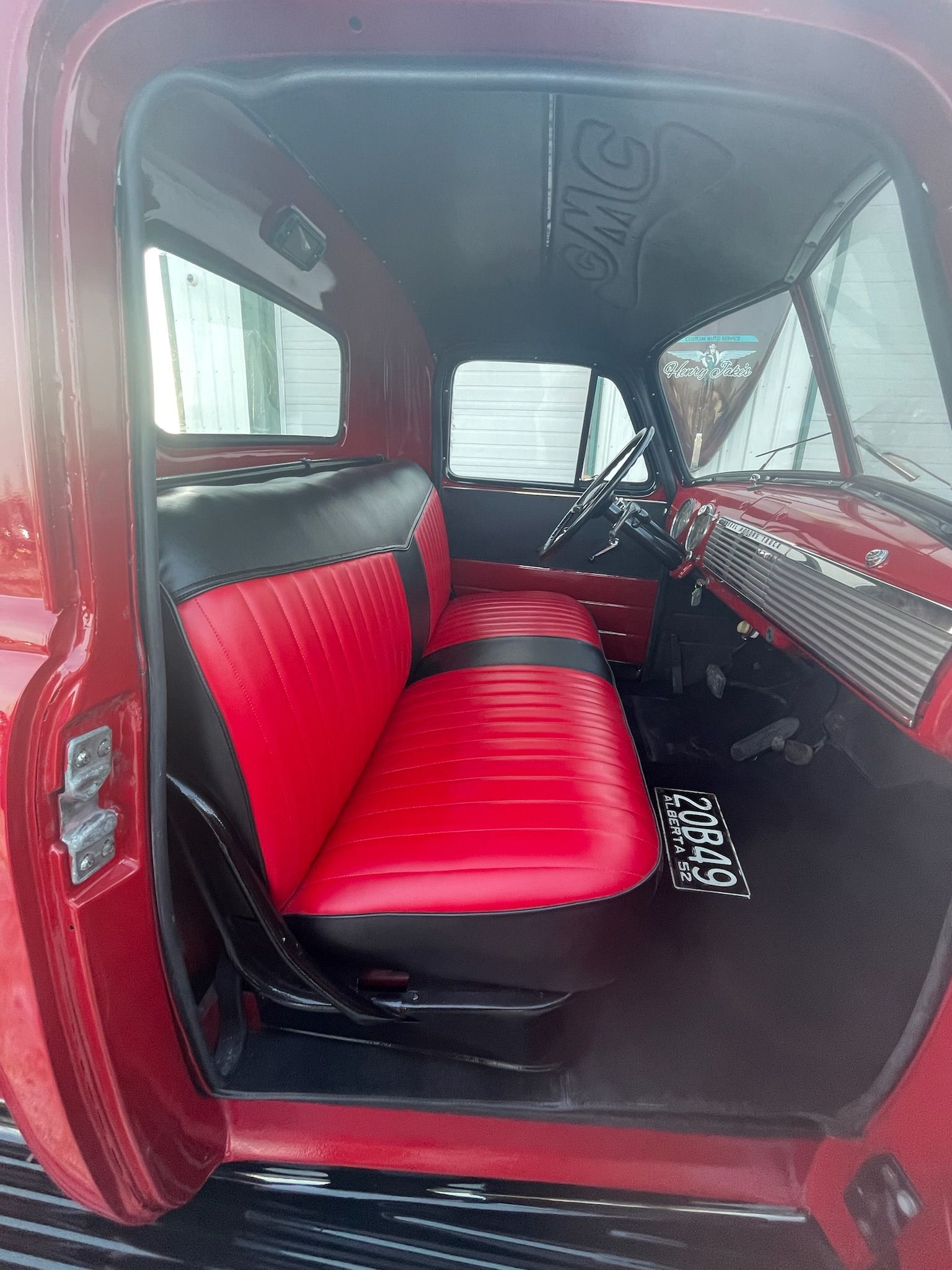 The inside of a red truck with red and black seats.