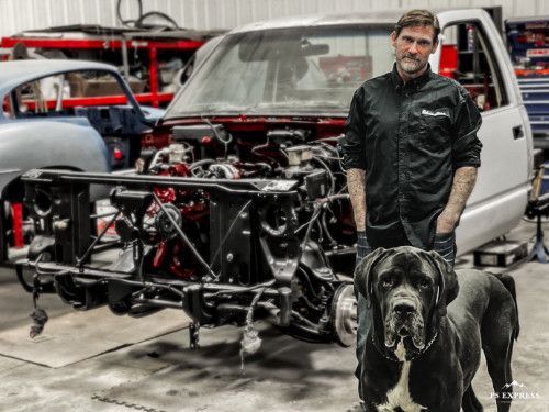 Man and dog in front of a car