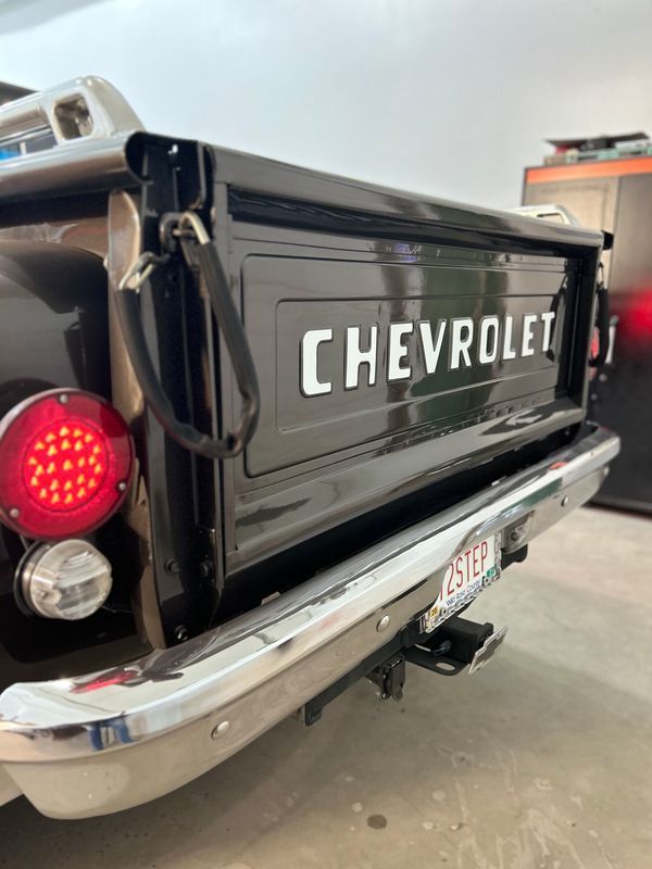 A black chevrolet truck is parked in a garage.