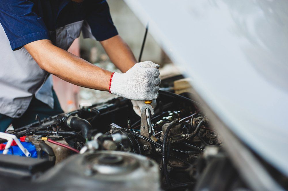A Man Is Working on The Engine of A Car — Fletcher's Truck and 4WD Repair Centre in Hallidays Point, NSW