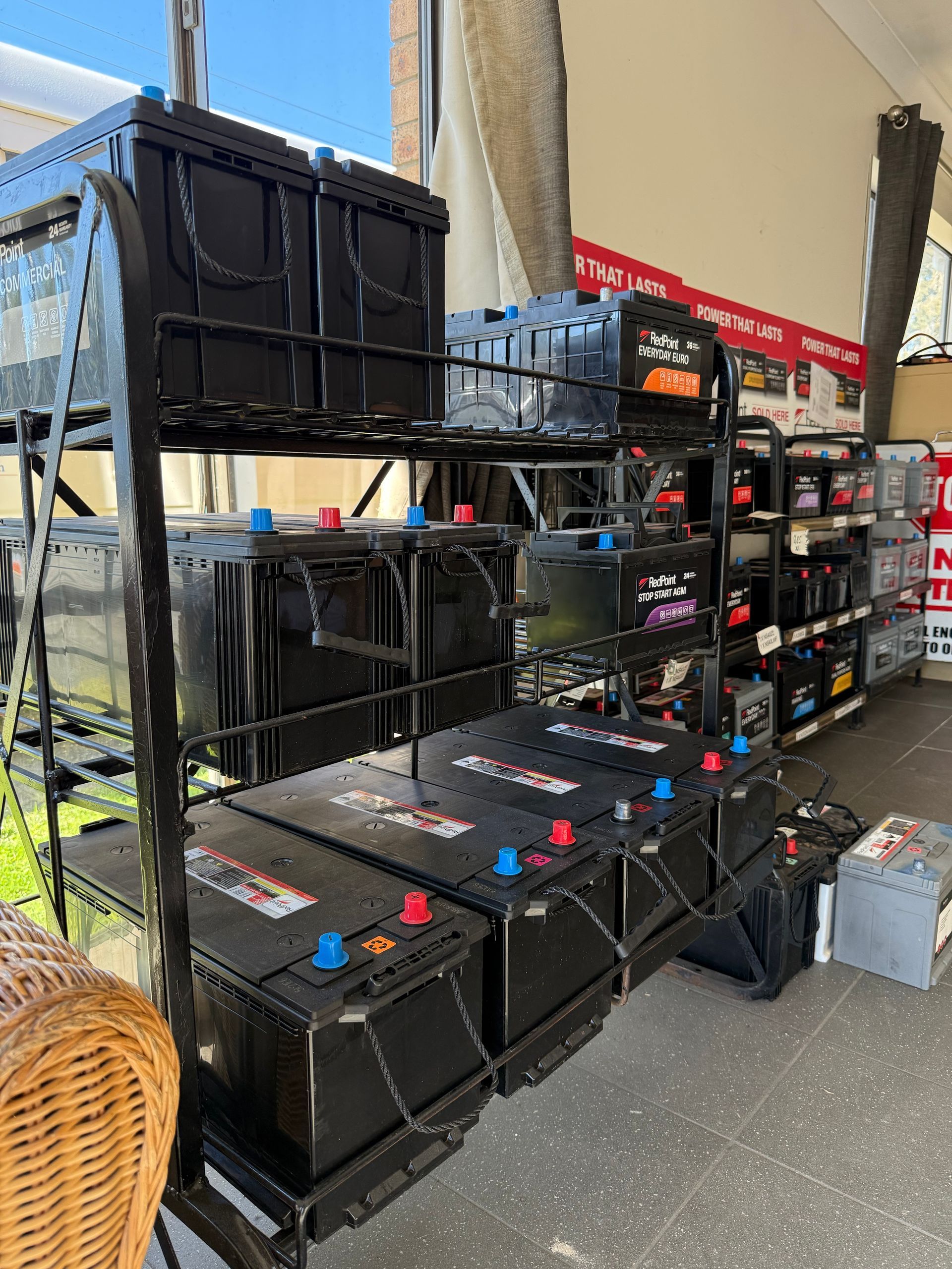 Stacked black storage crates and bins displayed outside a store aisle.