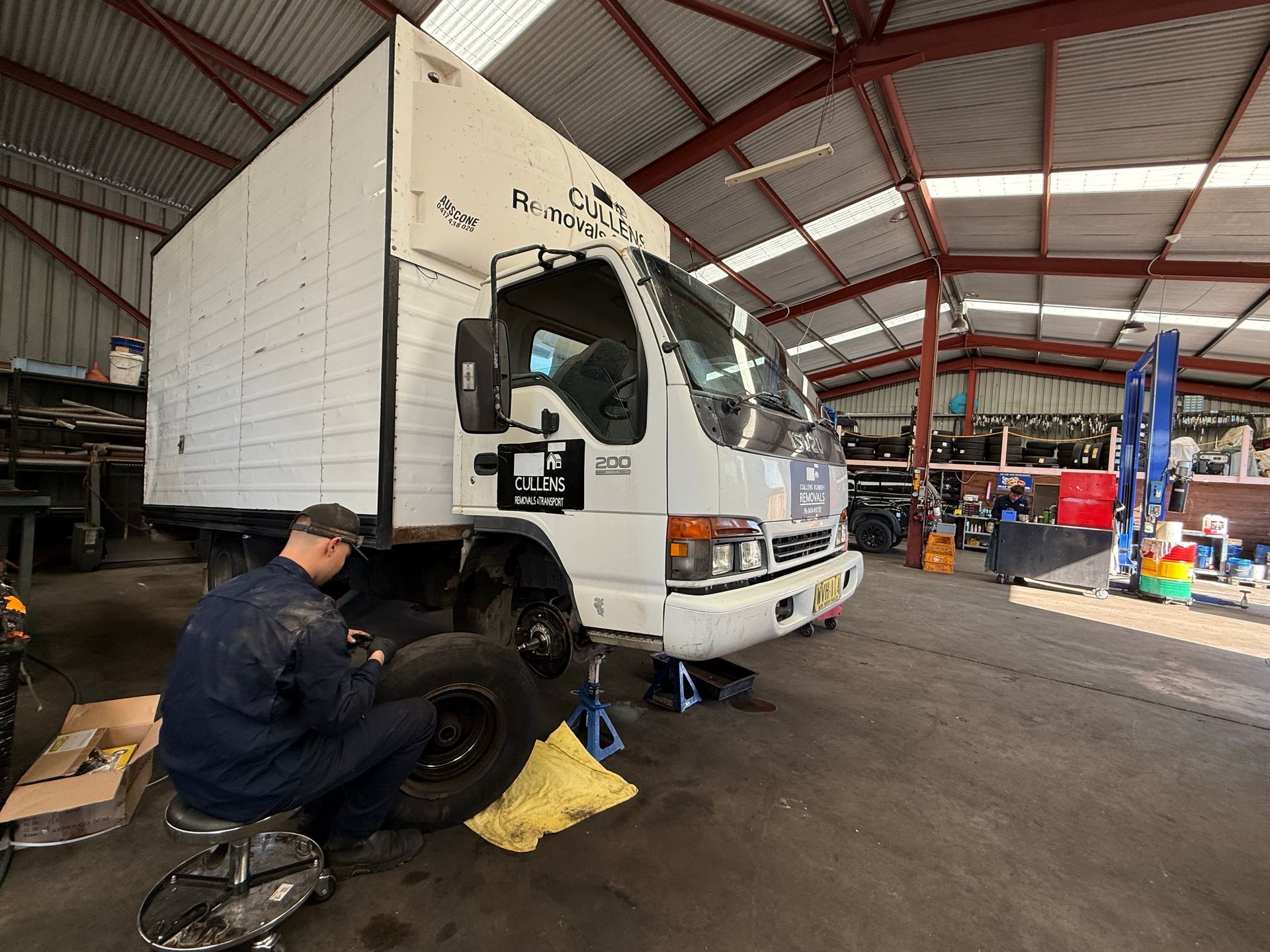 Mechanic changing a truck tire inside a warehouse garage