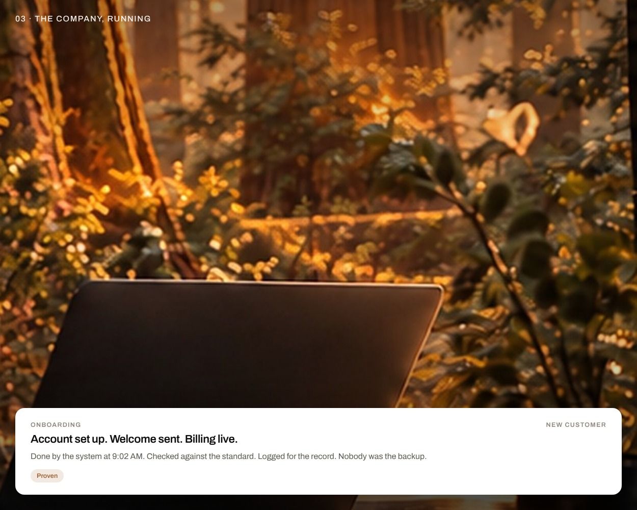A laptop on a desk in warm forest light, nobody at it, with a card reading 