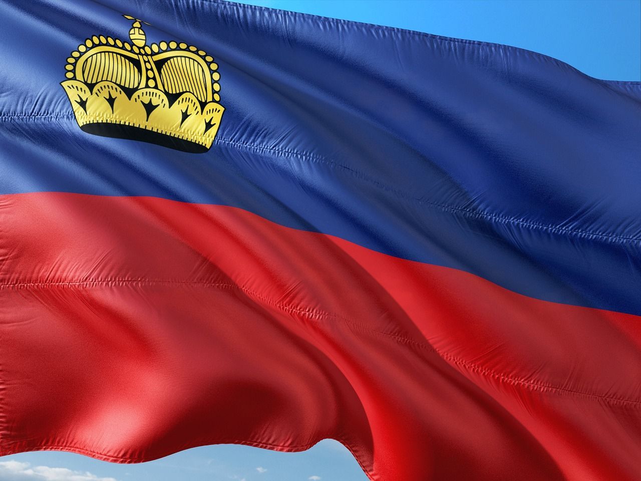 Liechtensteins flagga vajar, blå över rött, guldkrona uppe till vänster.