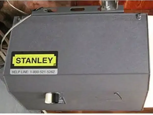 a Stanley garage door opener is hanging from the ceiling of a garage