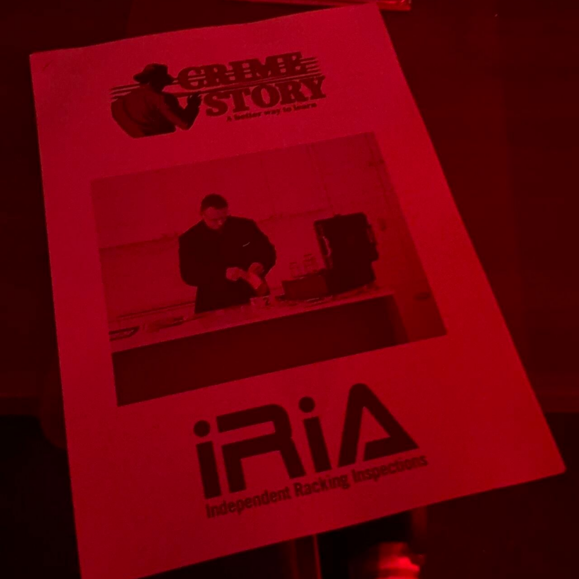 Flyer illuminated in red light.  Grime TV Story logo. Black and white photo of a person. Below, text: iRIA.