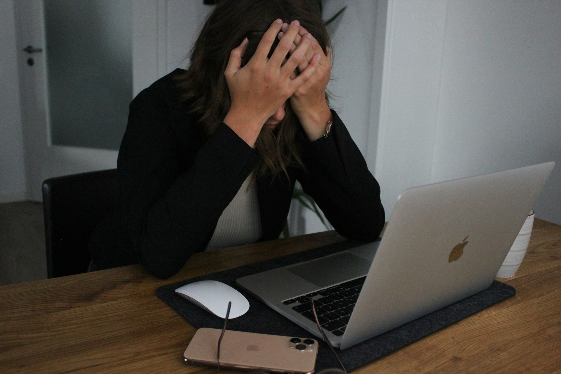 Woman stressed, hands covering face.
