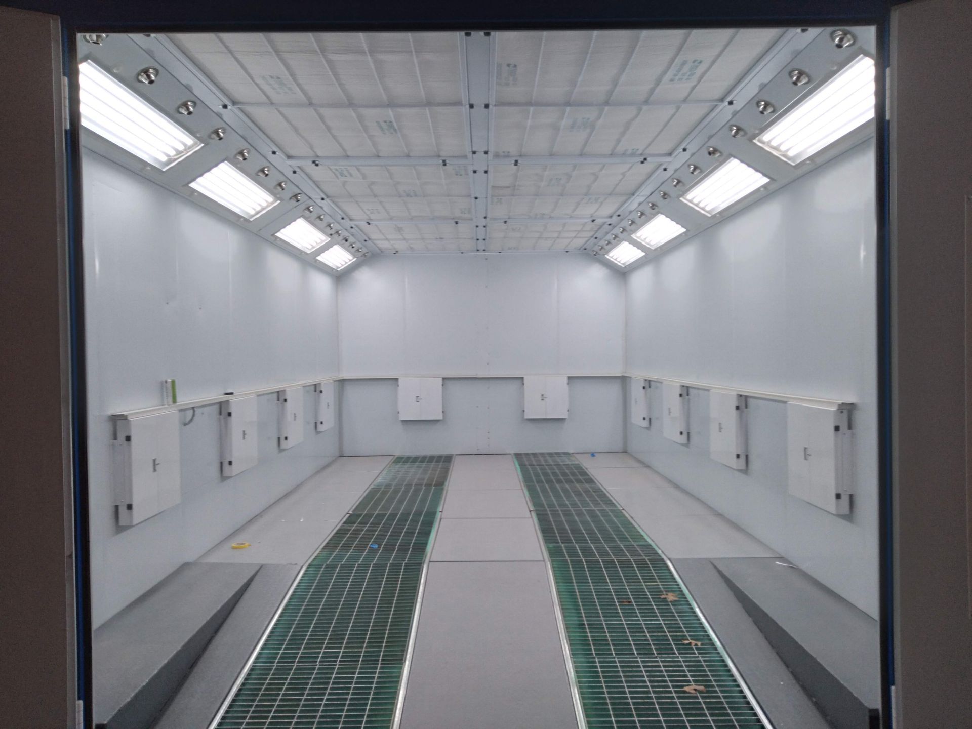 An empty room with a green floor and white walls