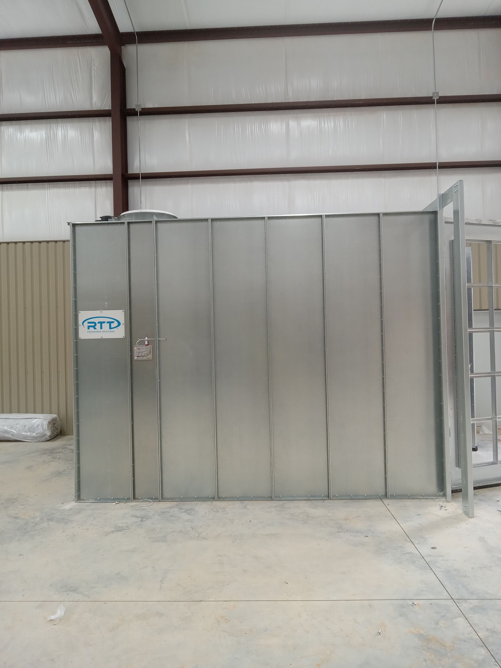 A large metal building with a sign on the side that says sra