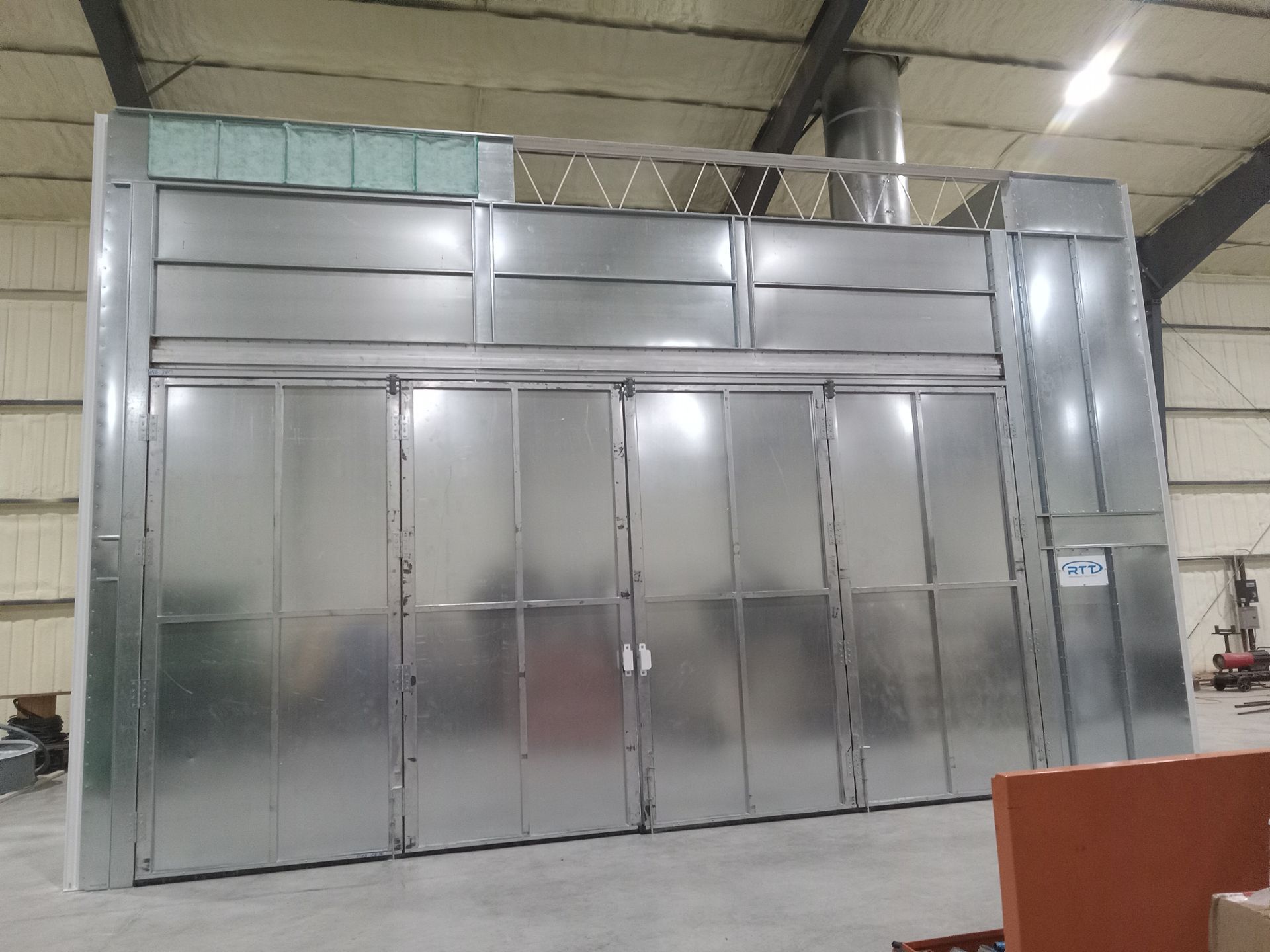A large metal building with a lot of doors in a warehouse.