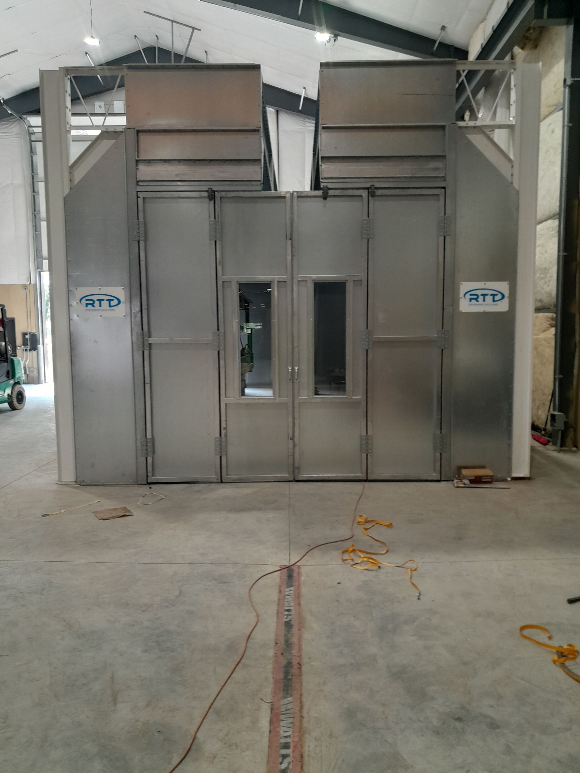 A large stainless steel building with a lot of doors and windows in a warehouse.