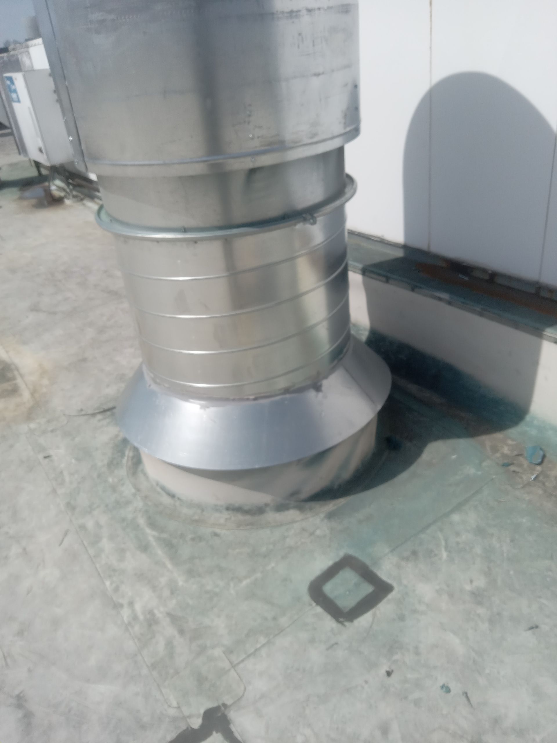 A large metal pipe is sitting on top of a concrete floor.