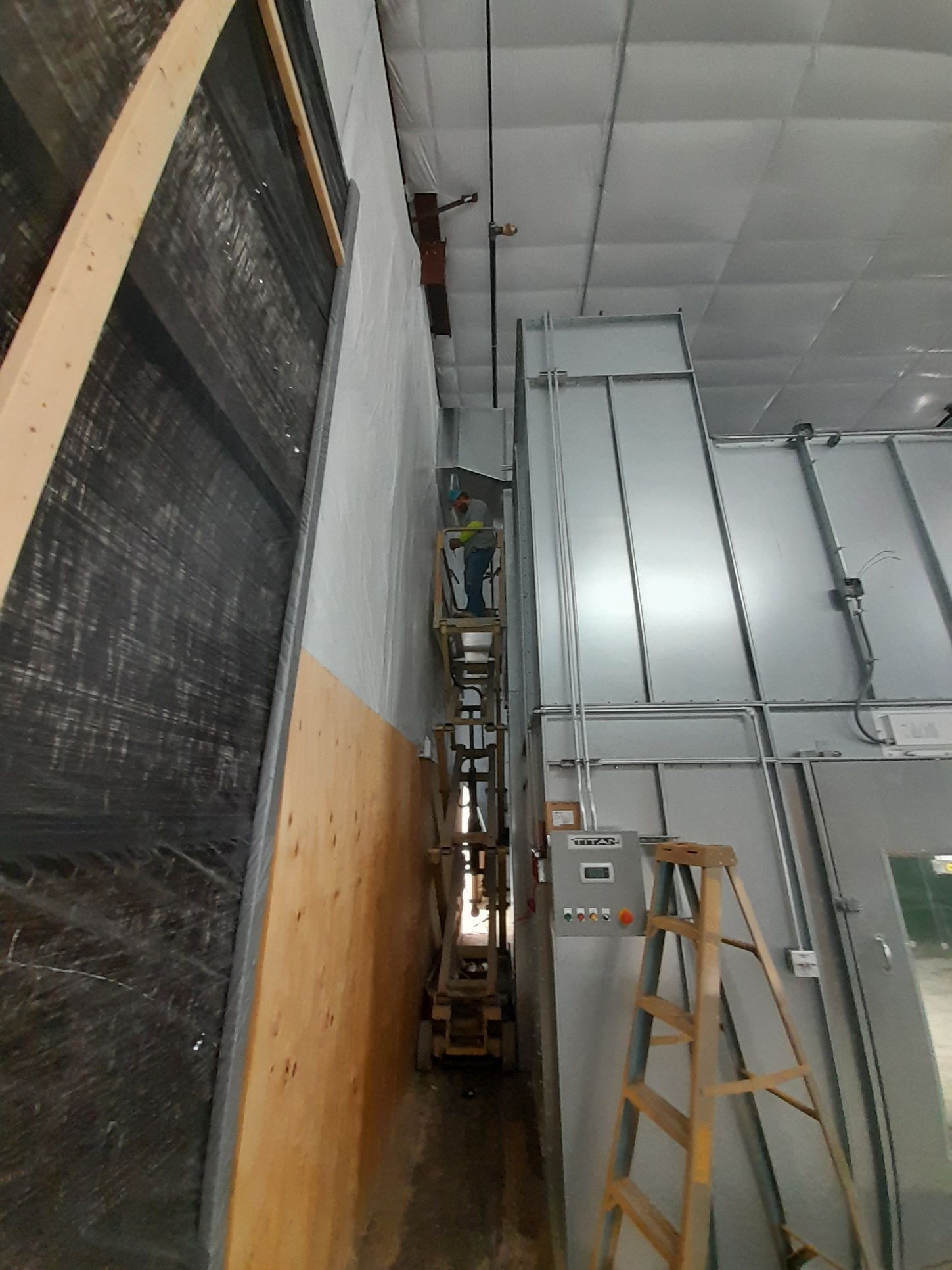 A man is standing on a ladder in a building.